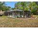 Screened-in pool area with mature landscaping, offering a relaxing and private outdoor space at 581 Ne 44Th Ave, Ocala, FL 34470