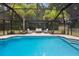 Sparkling backyard swimming pool with screened enclosure, patio furniture, and lush landscaping at 581 Ne 44Th Ave, Ocala, FL 34470