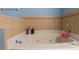 Bathroom with a jetted soaking tub and tiled walls at 603 Marion Oaks Blvd, Ocala, FL 34473