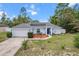 Charming single-story home with a well-maintained front yard, blue door, and attached two car garage at 603 Marion Oaks Blvd, Ocala, FL 34473