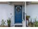 Bright blue front door with wreath, with an open storm door, and welcoming plants at 603 Marion Oaks Blvd, Ocala, FL 34473