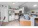 A bright kitchen with white cabinets, stainless steel appliances, and a view into the living room at 603 Marion Oaks Blvd, Ocala, FL 34473