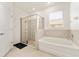 Bathroom featuring a walk-in shower and bathtub, providing a luxurious and comfortable experience at 6175 Sw 88Th Loop, Ocala, FL 34476