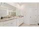 Bright bathroom with double granite vanity, white cabinets, a tiled floor, and a glass shower at 6175 Sw 88Th Loop, Ocala, FL 34476