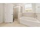 Bathroom featuring a glass shower and soaking tub, offering a serene retreat within the home at 6175 Sw 88Th Loop, Ocala, FL 34476