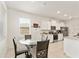 Bright eat-in kitchen features white cabinets, stainless steel appliances, and a glass table with seating for four at 6175 Sw 88Th Loop, Ocala, FL 34476