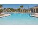 Sparkling community pool bordered by lounge chairs and palm trees, offering a serene outdoor retreat at 6175 Sw 88Th Loop, Ocala, FL 34476
