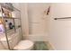 Bathroom with a shower, neutral floor tiles, and practical shelving unit for toiletries at 6250 Se 88Th St, Ocala, FL 34472