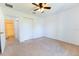 Bright bedroom featuring neutral carpet, a ceiling fan, and closet with easy access to the bathroom at 6250 Se 88Th St, Ocala, FL 34472