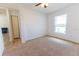 Bright bedroom features neutral carpet, a ceiling fan, and a window providing natural light at 6250 Se 88Th St, Ocala, FL 34472