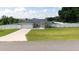Well-kept single story home with a two-car garage, green lawn and white fence under a sunny sky at 6250 Se 88Th St, Ocala, FL 34472