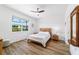 Brightly lit bedroom with a view to the screened lanai through the window and ceiling fan at 8905 Sw 76Th Ln, Ocala, FL 34481