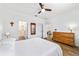 The primary bedroom features wood look flooring, ensuite bath, and hallway access at 8905 Sw 76Th Ln, Ocala, FL 34481