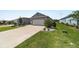Well-manicured lawn and landscaped area featuring a long driveway leading to the two-car garage at 8905 Sw 76Th Ln, Ocala, FL 34481