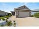 Exterior shot featuring a manicured front yard with fresh landscaping, a gray exterior, and a two-car garage at 8905 Sw 76Th Ln, Ocala, FL 34481