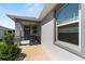 Inviting front porch featuring decorative columns and a gray front door with sidelight windows at 8905 Sw 76Th Ln, Ocala, FL 34481
