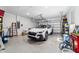 Clean garage with epoxy floors, equipped with ample storage, and housing a modern white SUV, offering convenience and practicality at 8905 Sw 76Th Ln, Ocala, FL 34481