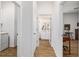 Bright hallway with light walls, wood floors, and access to bathroom and laundry, providing functionality and visual appeal at 8905 Sw 76Th Ln, Ocala, FL 34481