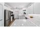 Open kitchen with modern stainless-steel appliances, white cabinets, and eat-in countertop at 8905 Sw 76Th Ln, Ocala, FL 34481
