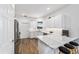 Bright kitchen with stainless appliances, eat-in countertop, white cabinets, and wood-look flooring at 8905 Sw 76Th Ln, Ocala, FL 34481