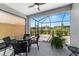 Inviting screened lanai with a ceiling fan, overlooking the backyard, and furnished with an outdoor dining set at 8905 Sw 76Th Ln, Ocala, FL 34481