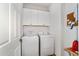 Efficient laundry room with full size washer and dryer, storage cabinets, and bright lighting at 8905 Sw 76Th Ln, Ocala, FL 34481