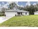 Charming single-story home with a well-maintained lawn, attached two-car garage, and welcoming front entrance at 8937 Se Highway 42, Summerfield, FL 34491