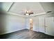 This spacious bedroom includes gray flooring, a ceiling fan, and an ensuite bathroom at 9 Hemlock Terrace Ln, Ocala, FL 34472