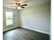 Bedroom with a ceiling fan, gray flooring, white walls, and a window at 9 Hemlock Terrace Ln, Ocala, FL 34472