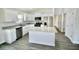 Bright kitchen features white cabinets, stainless steel appliances, granite countertops, and an island at 9 Hemlock Terrace Ln, Ocala, FL 34472