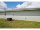 Side yard with green grass and an air conditioning unit on a sunny day at 9 Hemlock Terrace Ln, Ocala, FL 34472