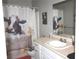 Charming bathroom with a unique shower curtain, a spacious vanity, and decorative accents at 25600 Se 152Nd Pl, Umatilla, FL 32784