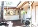 View of the wooden deck with hanging plants, a bench, and an outdoor faucet with hose reel at 25600 Se 152Nd Pl, Umatilla, FL 32784