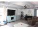 Cozy living room with a fireplace, ceiling fans, hardwood floors, and comfortable seating area at 25600 Se 152Nd Pl, Umatilla, FL 32784