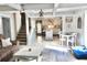 Open-concept living area with a cozy sofa, wood-look floors, and a view of the modern kitchen and dining area at 25600 Se 152Nd Pl, Umatilla, FL 32784