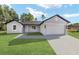 Charming single-story home featuring a lush green lawn and a two-car garage at 5 Willow Trl, Ocala, FL 34472