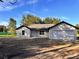A cozy one-story house with a two-car garage, set against a backdrop of tall trees at 5 Willow Trl, Ocala, FL 34472