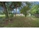 The backyard offers a green space with mature trees and a chain-link fence, providing privacy and shade at 5018 Se 106Th Pl, Belleview, FL 34420