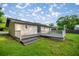 Rear exterior view showcasing a wooden deck, ideal for outdoor relaxation and entertaining at 6021 Nw 54Th Ter, Ocala, FL 34482