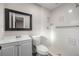Bathroom with a white vanity, toilet and tiled shower with grab bars at 6021 Nw 54Th Ter, Ocala, FL 34482