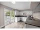 Bright kitchen featuring white cabinets, granite countertops, and stainless steel appliances with access to the backyard deck at 6021 Nw 54Th Ter, Ocala, FL 34482
