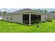 Well-maintained backyard featuring a screened-in porch and lush green lawn, perfect for outdoor relaxation at 7828 Sw 74Th Loop, Ocala, FL 34481