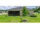 Backyard featuring a well-maintained lawn, screened porch, and young tree at 7828 Sw 74Th Loop, Ocala, FL 34481