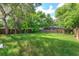 Large grassy backyard surrounded by mature trees and a wooden fence at 956 Osceola Trl, Casselberry, FL 32707