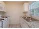 Functional kitchen showcasing modern appliances, granite countertops, and white cabinets at 956 Osceola Trl, Casselberry, FL 32707