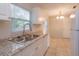 Well-equipped kitchen with stainless steel sink, granite countertops, and ample cabinet space at 956 Osceola Trl, Casselberry, FL 32707