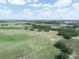 Expansive aerial view of a grassy property with scattered trees, a house, and a blue sky overhead at 4880 Bannon Island Rd, Haines City, FL 33844