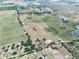 Aerial view of a farm land featuring a mix of open areas, a pond, structures, and nearby properties at 4880 Bannon Island Rd, Haines City, FL 33844