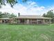 Charming country home featuring a large covered porch, stone accents, and a two-car carport at 4880 Bannon Island Rd, Haines City, FL 33844