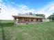 Spacious single-story home featuring a large porch, rustic stonework, and a well-maintained lawn at 4880 Bannon Island Rd, Haines City, FL 33844